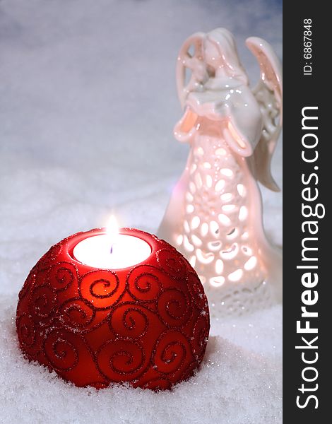 An image of glass balls with candle on snow