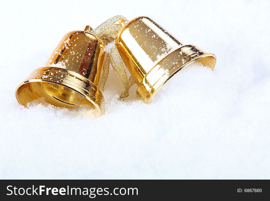 Gold Christmas bells over snow