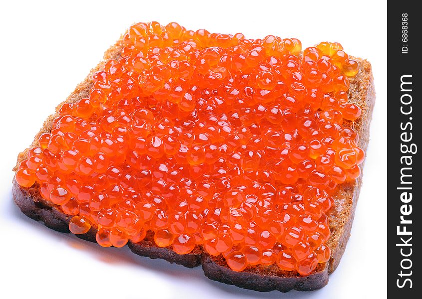 Red caviar on brown bread; Objects on white background. Red caviar on brown bread; Objects on white background