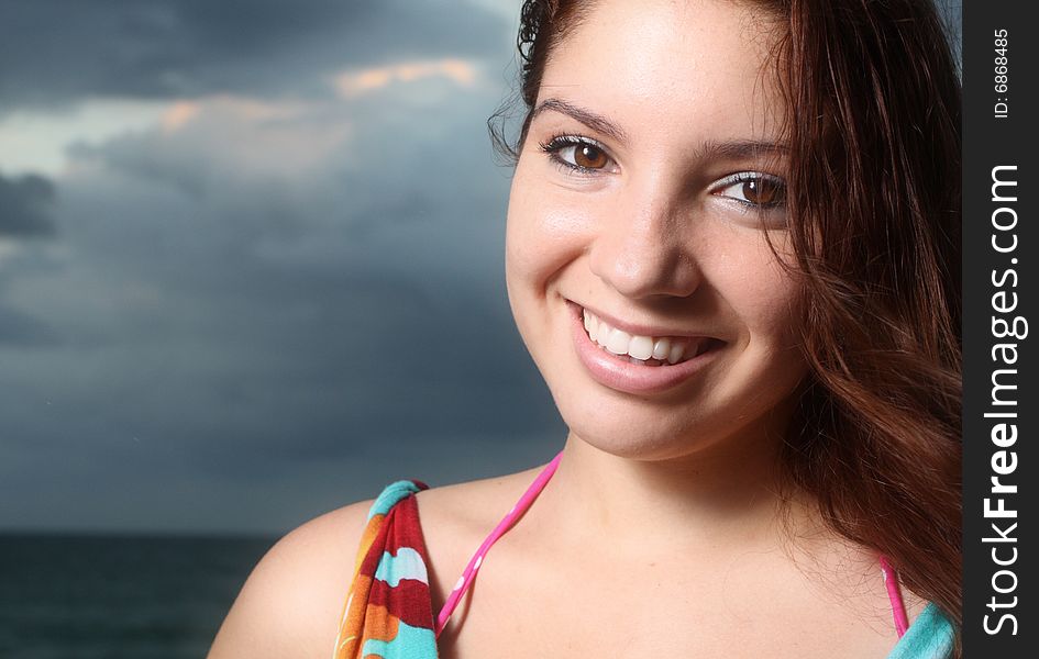 Young female smiling with cloudy sky background. Young female smiling with cloudy sky background