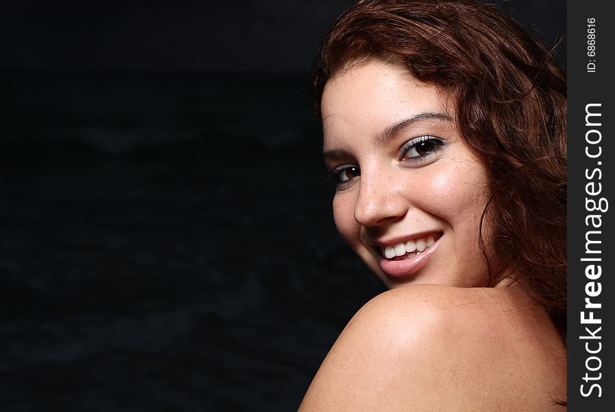 Young female smiling over her shoulder. Young female smiling over her shoulder