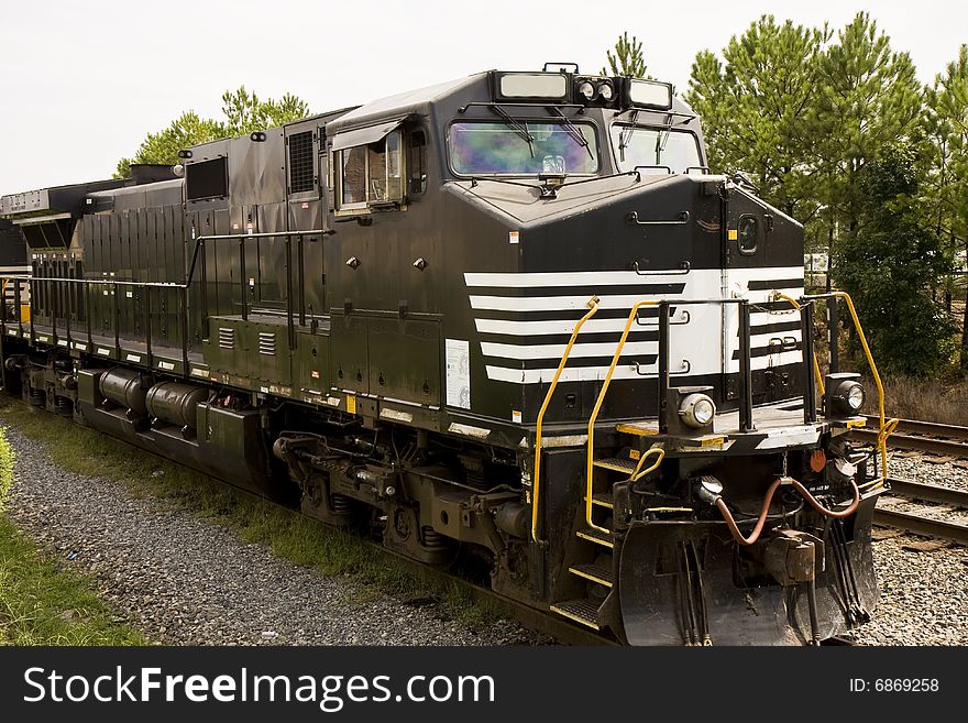 A black and white railroad locomotive on a track. A black and white railroad locomotive on a track