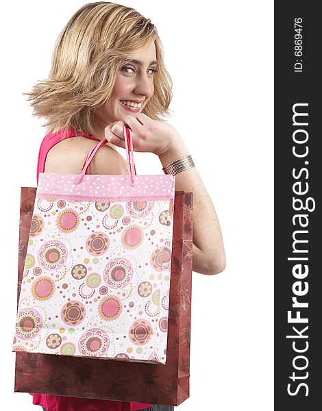 Portrait of a beautiful young blonde woman wearing a pink fashionable top and holding shopping bags over her shoulder. Isolated on white background. Portrait of a beautiful young blonde woman wearing a pink fashionable top and holding shopping bags over her shoulder. Isolated on white background