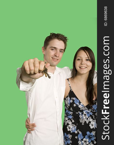 Couple showing house key over green screen. Couple showing house key over green screen