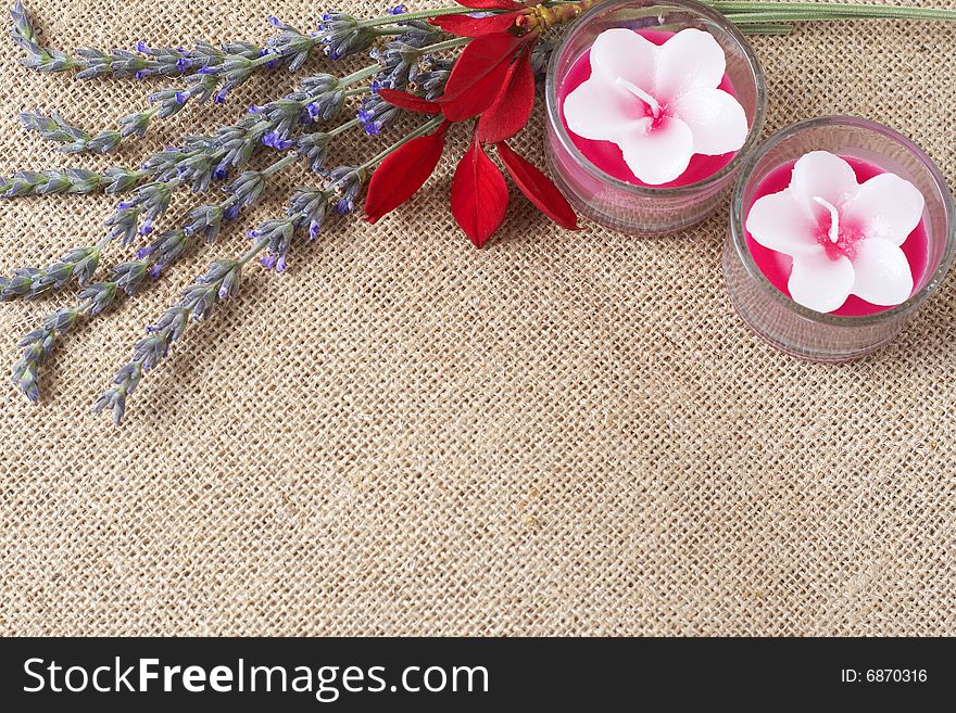 Beautiful lavender flowers and pink handmade candles on mesh background with copy space. Beautiful lavender flowers and pink handmade candles on mesh background with copy space