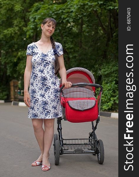 Young woman with red baby carriage. Young woman with red baby carriage