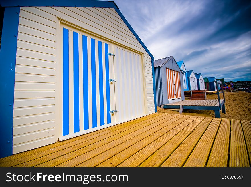 Colourful beach huts with dramatic sky