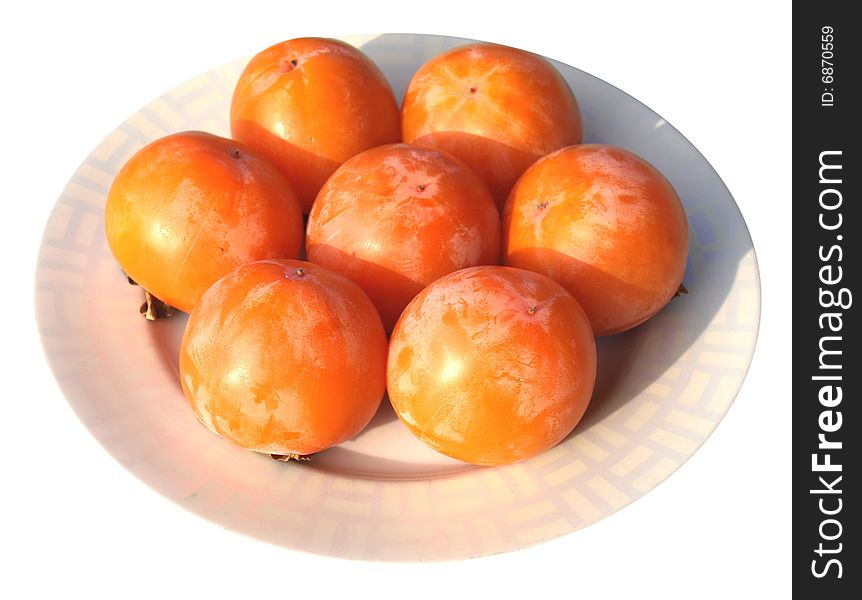 Orange persimmon fruits in a dish. Orange persimmon fruits in a dish