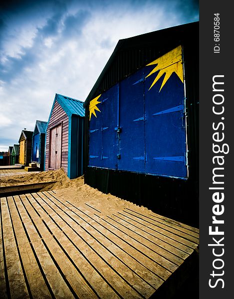 Colourful beach huts on the coastline with dramatic sky. Colourful beach huts on the coastline with dramatic sky