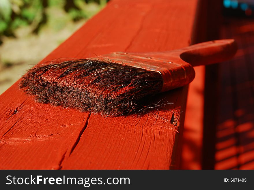 A couple of brushes soaked in red paint. A couple of brushes soaked in red paint