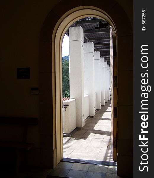 A row of white square columns through a doorway. A row of white square columns through a doorway