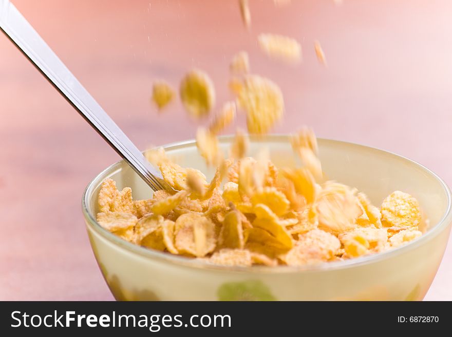 Corn flakes with milk and spoon on the table