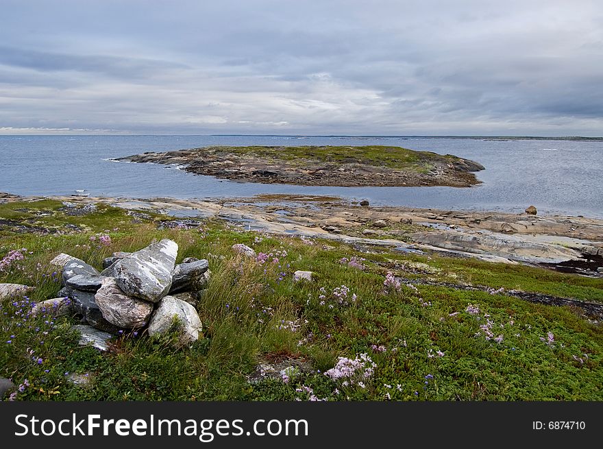 White sea 	(Russia) landscape with  island,  stones, moss and gray clouds. White sea 	(Russia) landscape with  island,  stones, moss and gray clouds