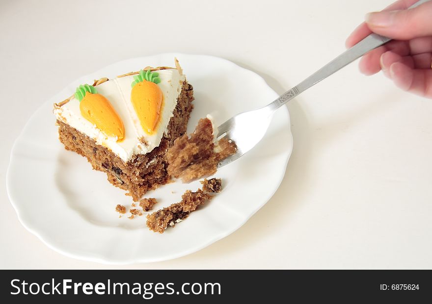 Using a fork to eat a slice of carrot cake