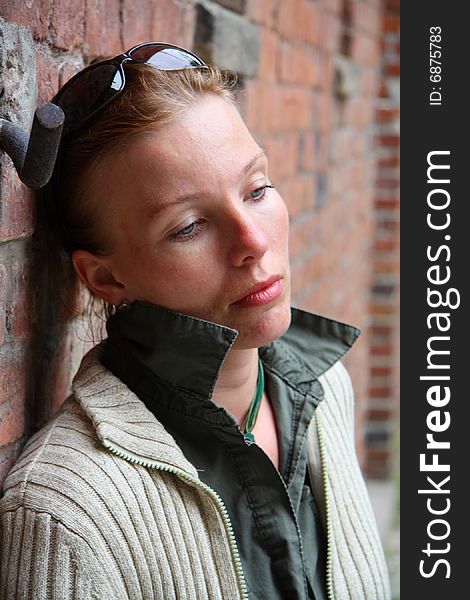 Portrait of unhappy woman near the brick wall. Portrait of unhappy woman near the brick wall