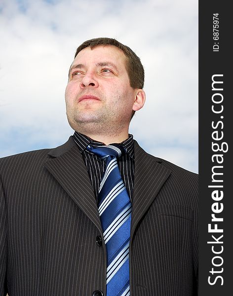 Portrait of young businessman over cloudy sky. Portrait of young businessman over cloudy sky