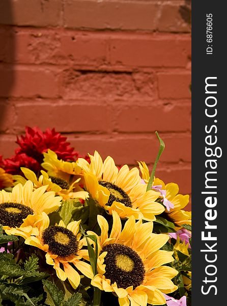 A spring bouquet with sunflowers in front of a brick wall. A spring bouquet with sunflowers in front of a brick wall