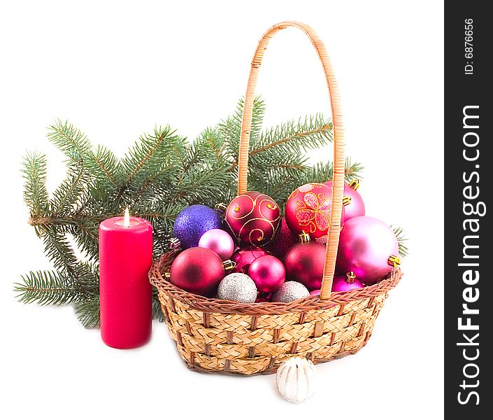 Yellow basket with New Year's spheres and green branch of fur-trees on white background. Yellow basket with New Year's spheres and green branch of fur-trees on white background