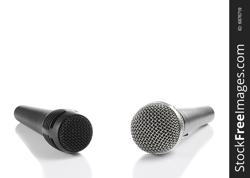 A black and a silver microphones isolated with copyspace. A black and a silver microphones isolated with copyspace.