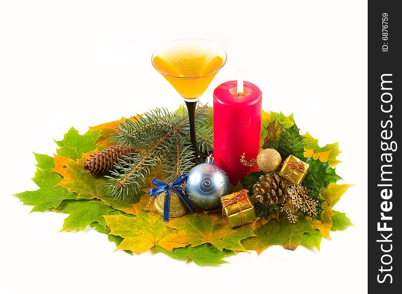 Carpet from autumn maple leaves with wine-glass dessert easy fault and red candle with New Year's decorations on white background. Carpet from autumn maple leaves with wine-glass dessert easy fault and red candle with New Year's decorations on white background