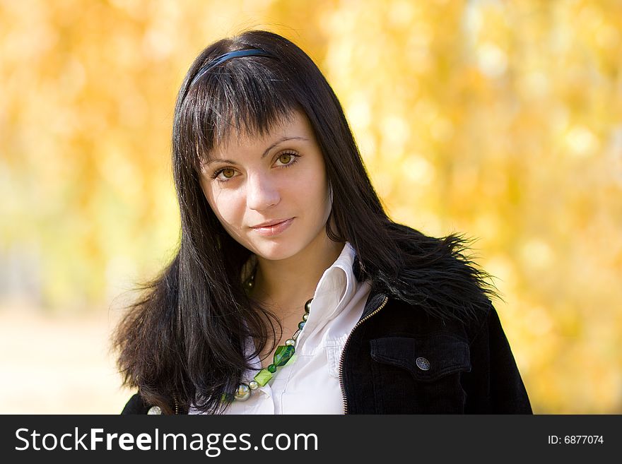 Young beautiful woman in the park over yellow autamn background. Young beautiful woman in the park over yellow autamn background