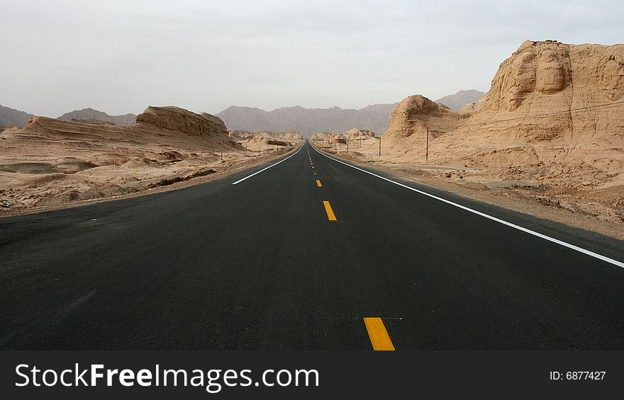 A long straight road with mountain on both sides, taken from Xinjiang, China. A long straight road with mountain on both sides, taken from Xinjiang, China