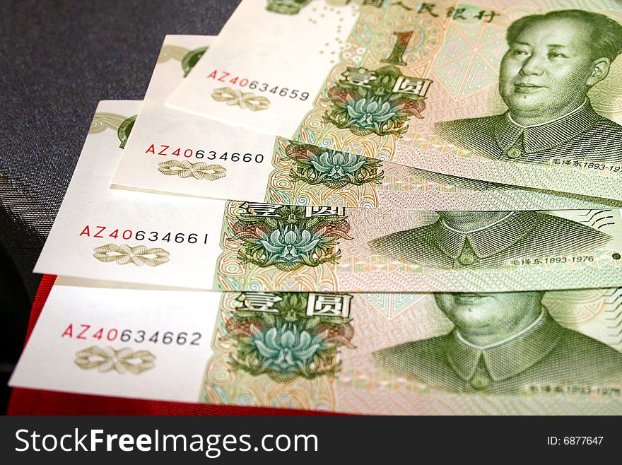 4 denominations advantage 1 yuan lie a fan on a table. On denominations the portrait Mao-Dze-Donne is represented.