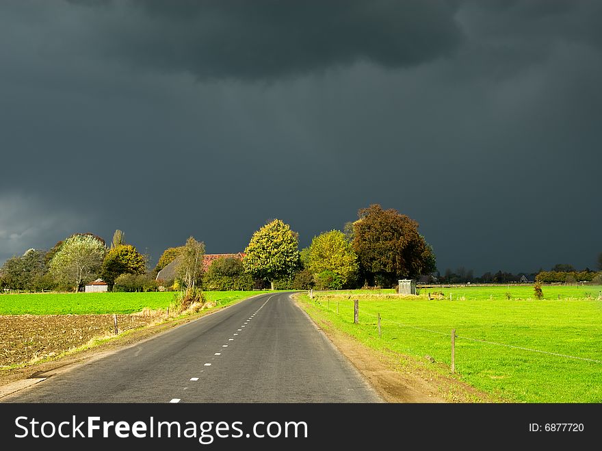 A road towards a dark autumn sky in the Netherlands