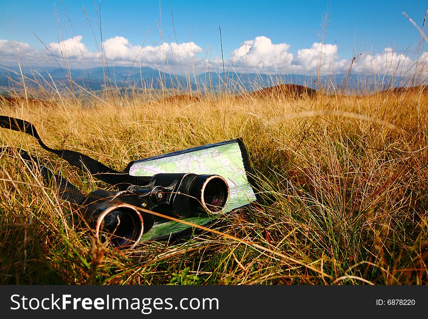An image of binoculars and map on grass. An image of binoculars and map on grass