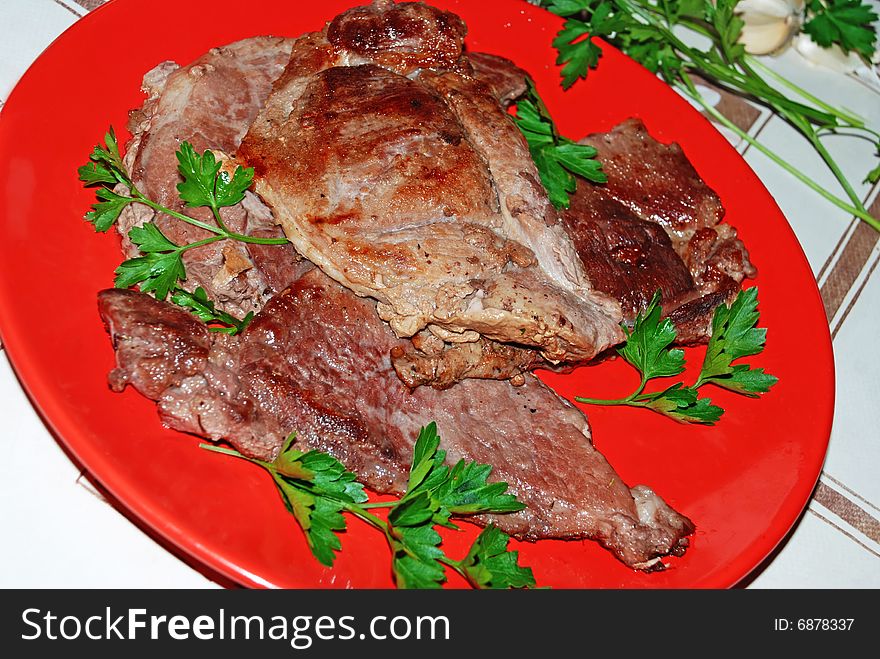 Fried mead over red plate served parsley. Fried mead over red plate served parsley