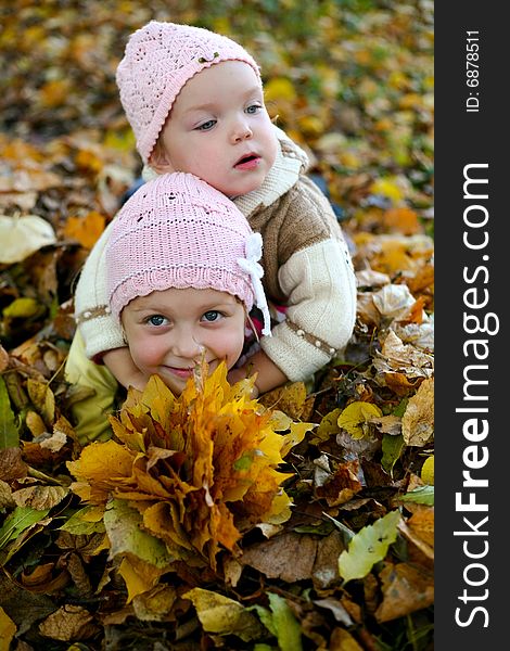Two sisters playing with leaves in autumn park. Two sisters playing with leaves in autumn park