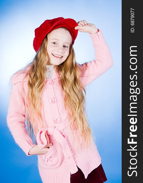 Smiling little girl in red cap, studio shot