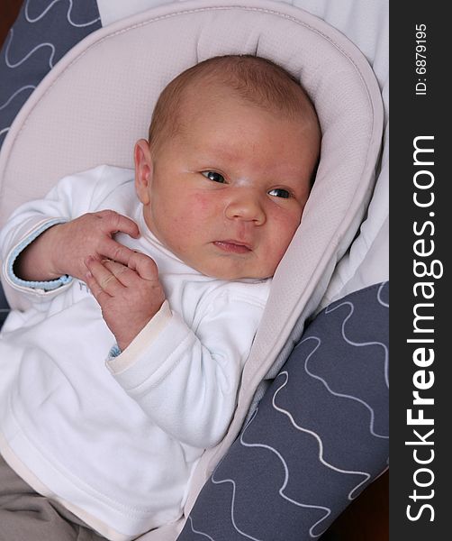 Newborn baby lying in bouncer chair