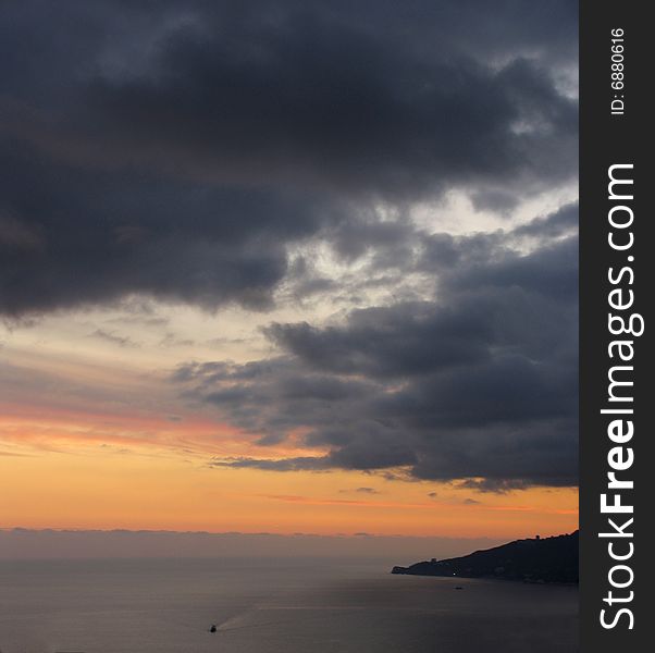 Sunset with large rain clouds above a sea