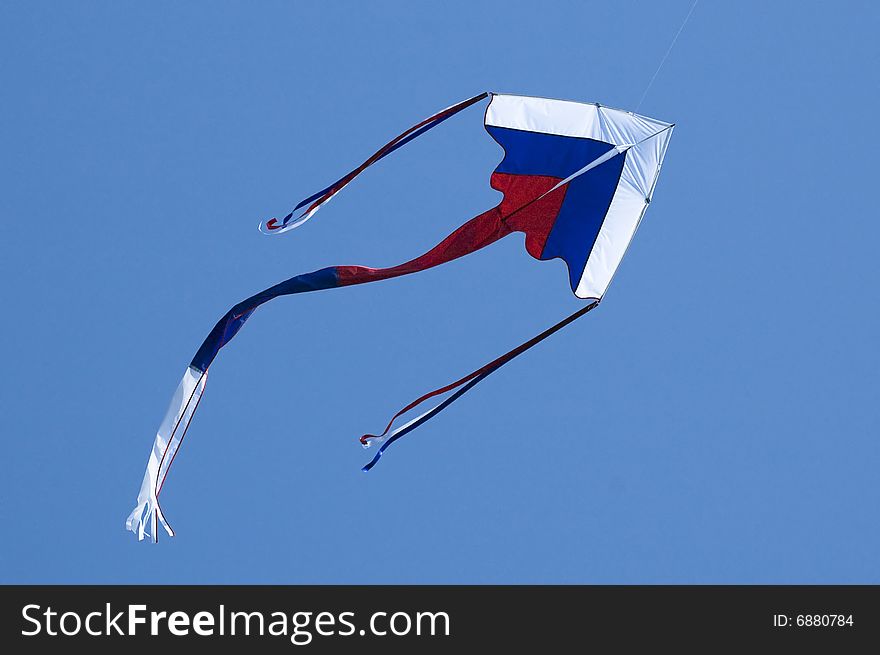 Kite coloured like Russian flag in the blue sky