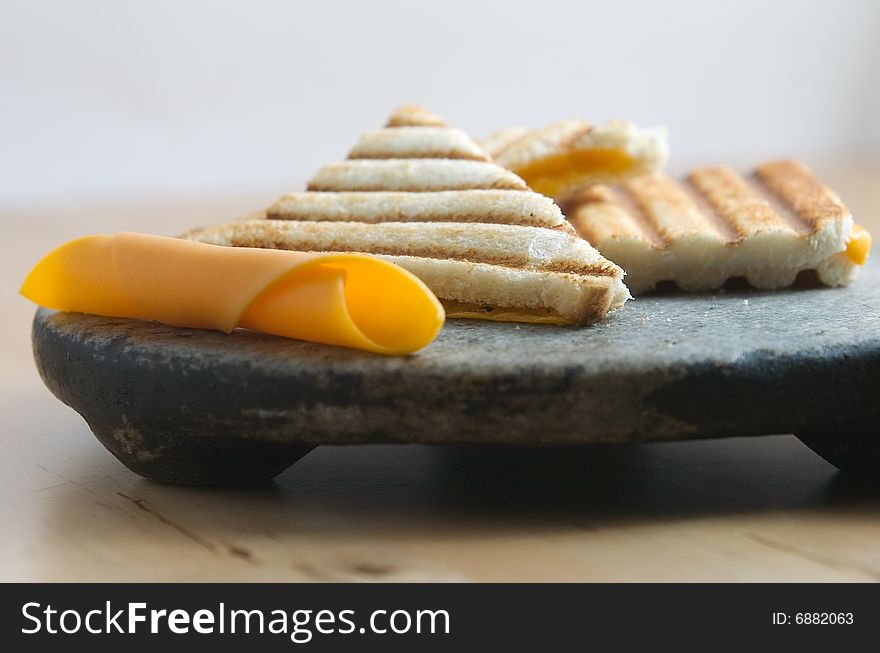Cheddar cheese tostie on stone plate. Cheddar cheese tostie on stone plate