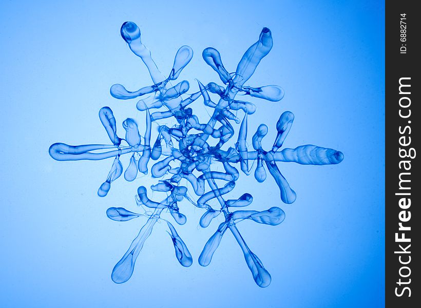 Glass transparent snowflake on blue. Glass transparent snowflake on blue