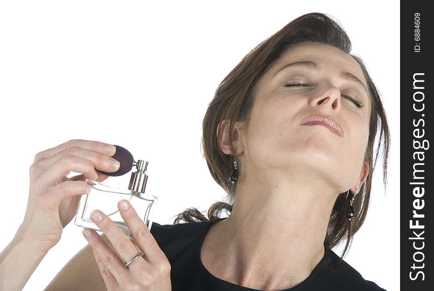 Sensual woman applying perfume on her body on a white background