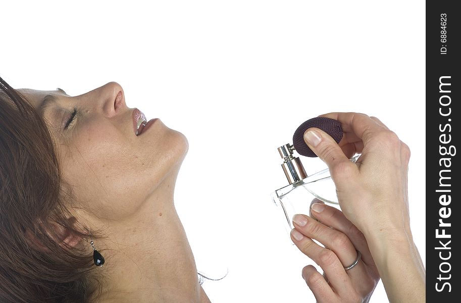 Sensual woman applying perfume on her body on a white background