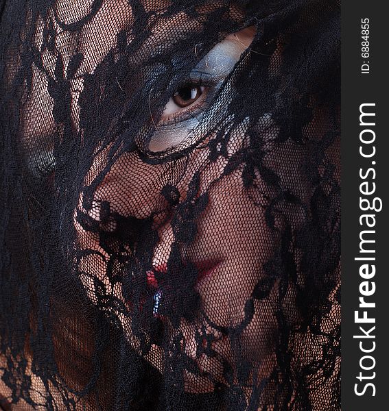 Woman face in a mask of black lace