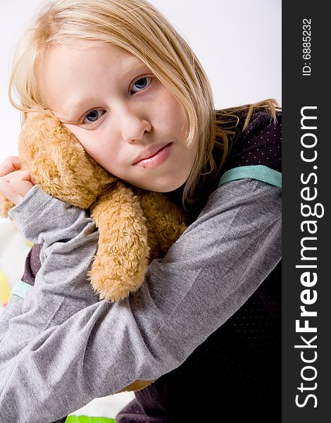 Happy blond girl hugging with her toy. Happy blond girl hugging with her toy
