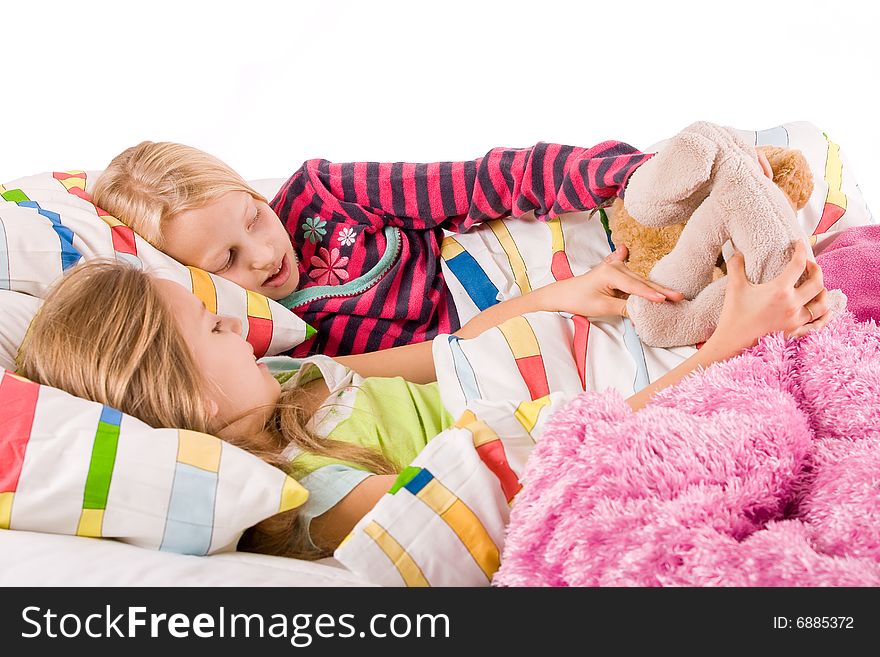 Two young children enjoying their colorful bed. Two young children enjoying their colorful bed