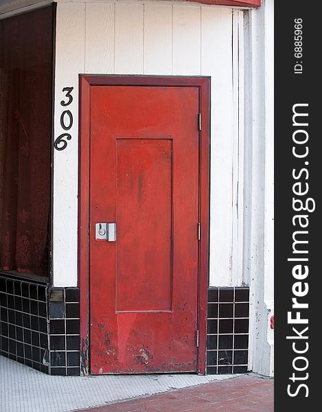 An image of a red wooden door with black tile
