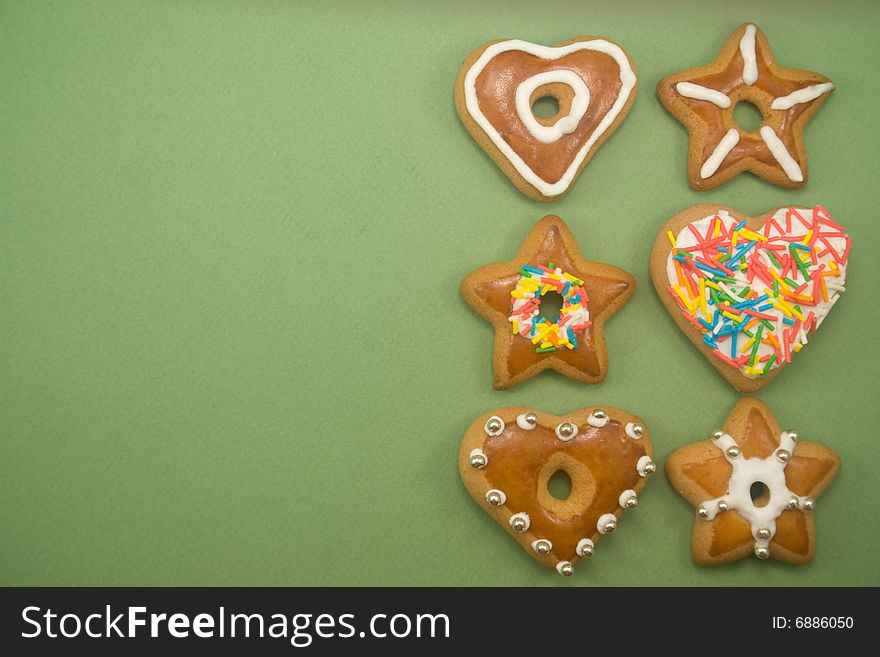 Six decorated gingerbread cookies on green with ad space on left. Six decorated gingerbread cookies on green with ad space on left