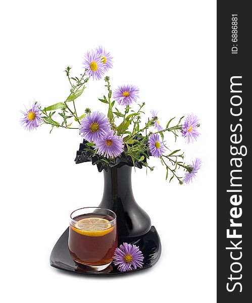 Blue autumn flowers black ceramic beautiful decorative vase and cognac tea lemon white background