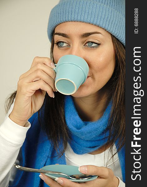 Chilly girl drinking from her cup of coffee