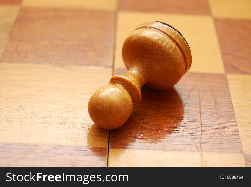 Fallen pawn on vintage chess board. Fallen pawn on vintage chess board