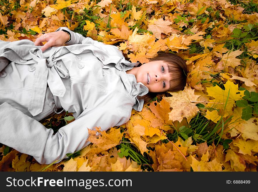 Young woman laying on a autumn leaves. Focus on the face. Vertical version in my portfolio. Young woman laying on a autumn leaves. Focus on the face. Vertical version in my portfolio.