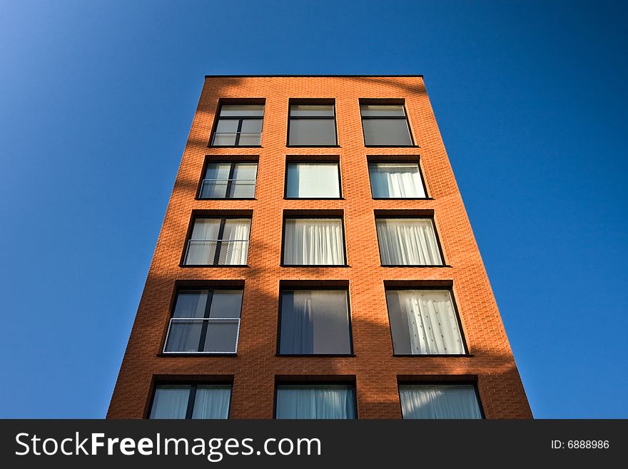 Brick building towering into the blue sky. Brick building towering into the blue sky.