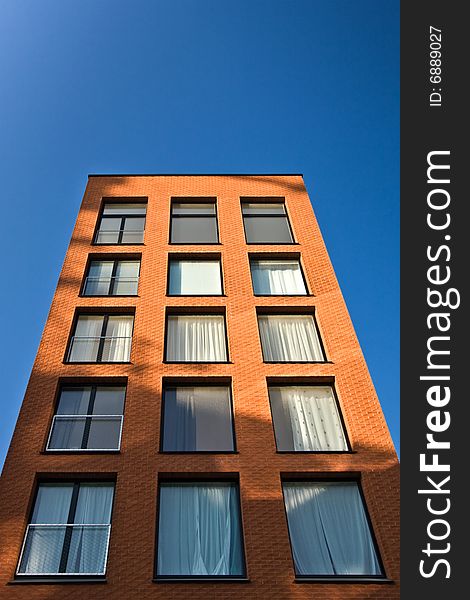 Tall brick building in the blue sky. Tall brick building in the blue sky.